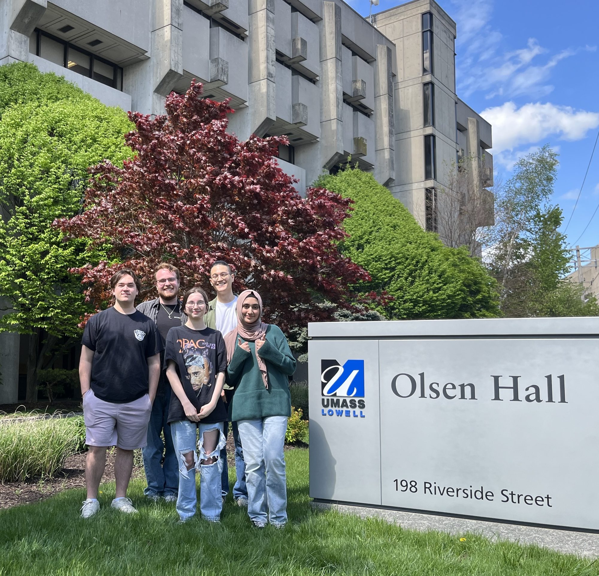 ZEAL lab members standing in front of the Olsen Hall sign at UMass Lowell
