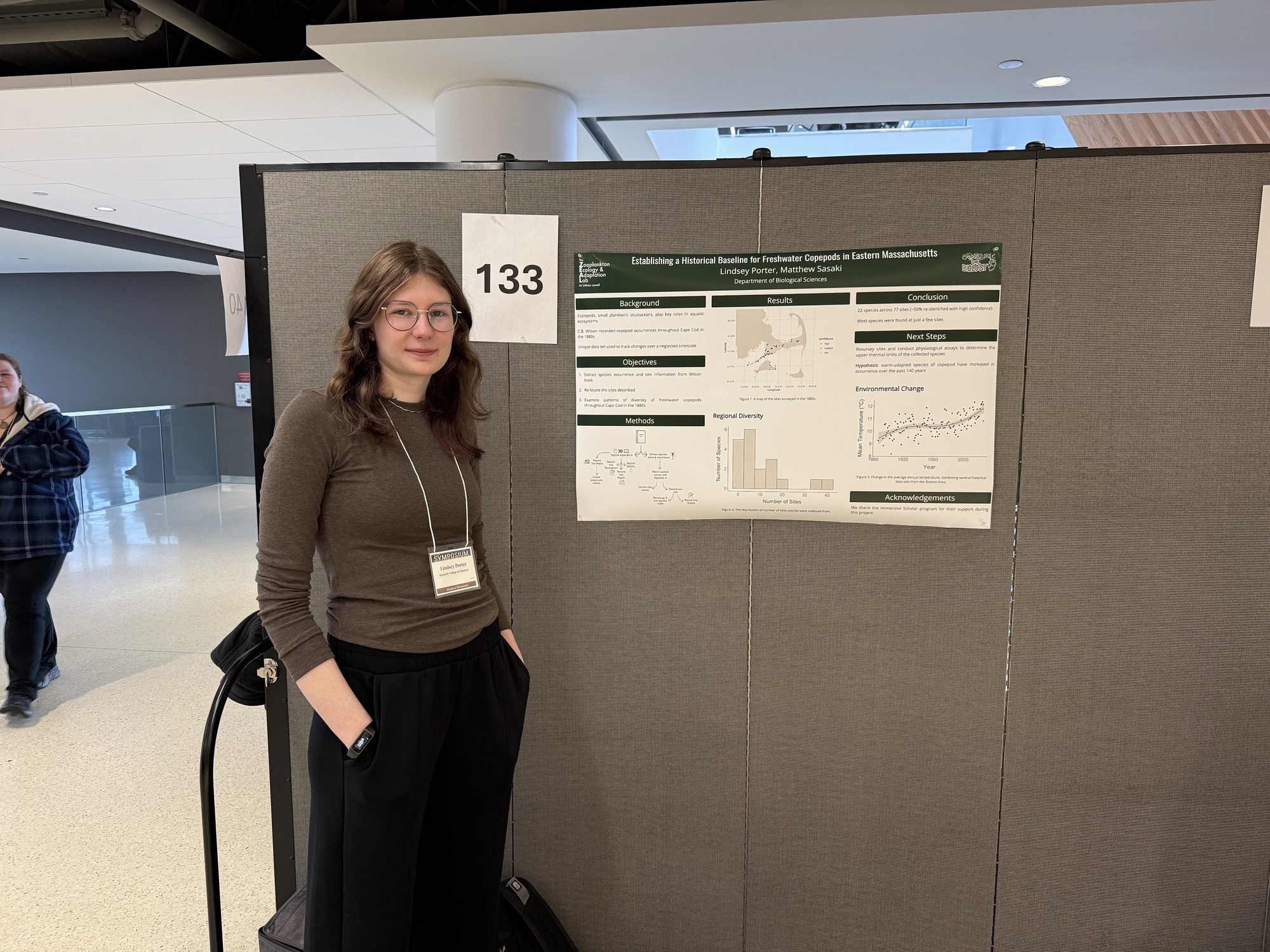 Lindsey standing beside her research poster